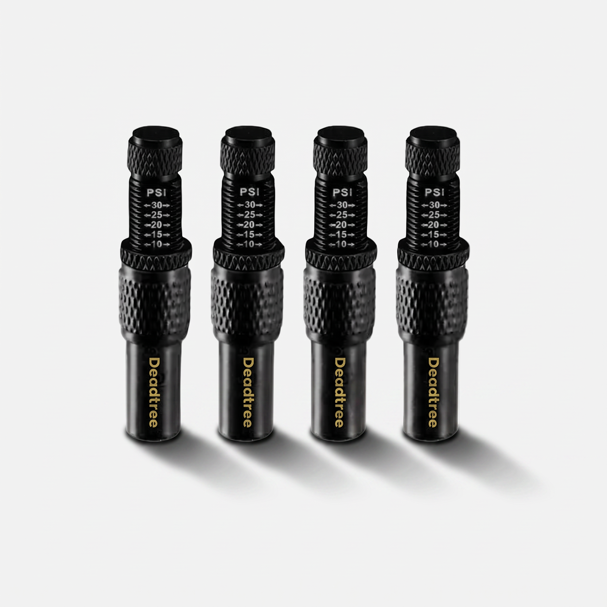 Four Deadtree adjustable tyre deflators with PSI scale, standing on a light surface with a soft cast shadow