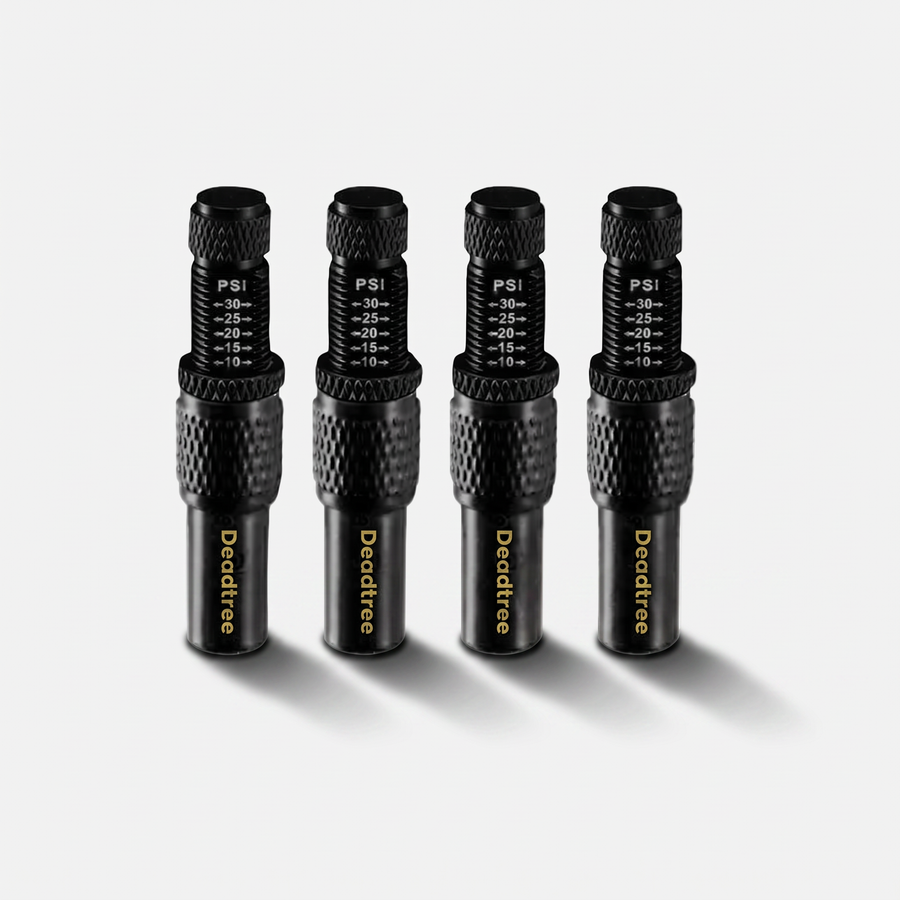 Four Deadtree adjustable tyre deflators with PSI scale, standing on a light surface with a soft cast shadow